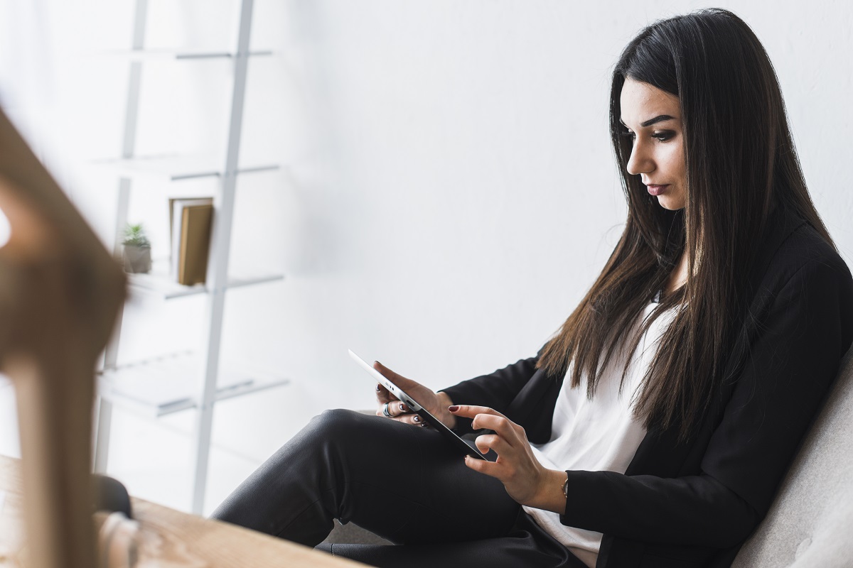 Mulher usando tablet no escritório para consulta em plataforma digital Mulher usando tablet no escritório para consulta em plataforma digital